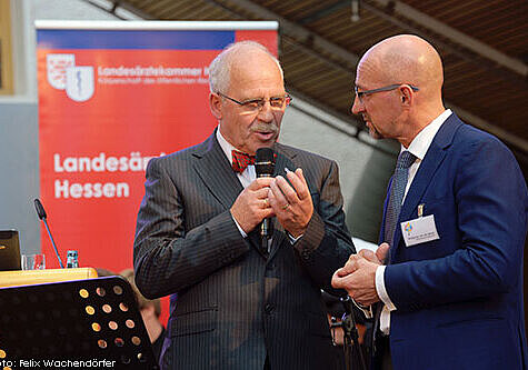 Foto von der Begrüßung mit Dr. med. Gottfried von Knoblauch zu Hatzbach, Präsident der Landesärztekammer Hessen, und Moderator Wolfgang van den Bergh, Chefredakteur der Ärzte Zeitung 