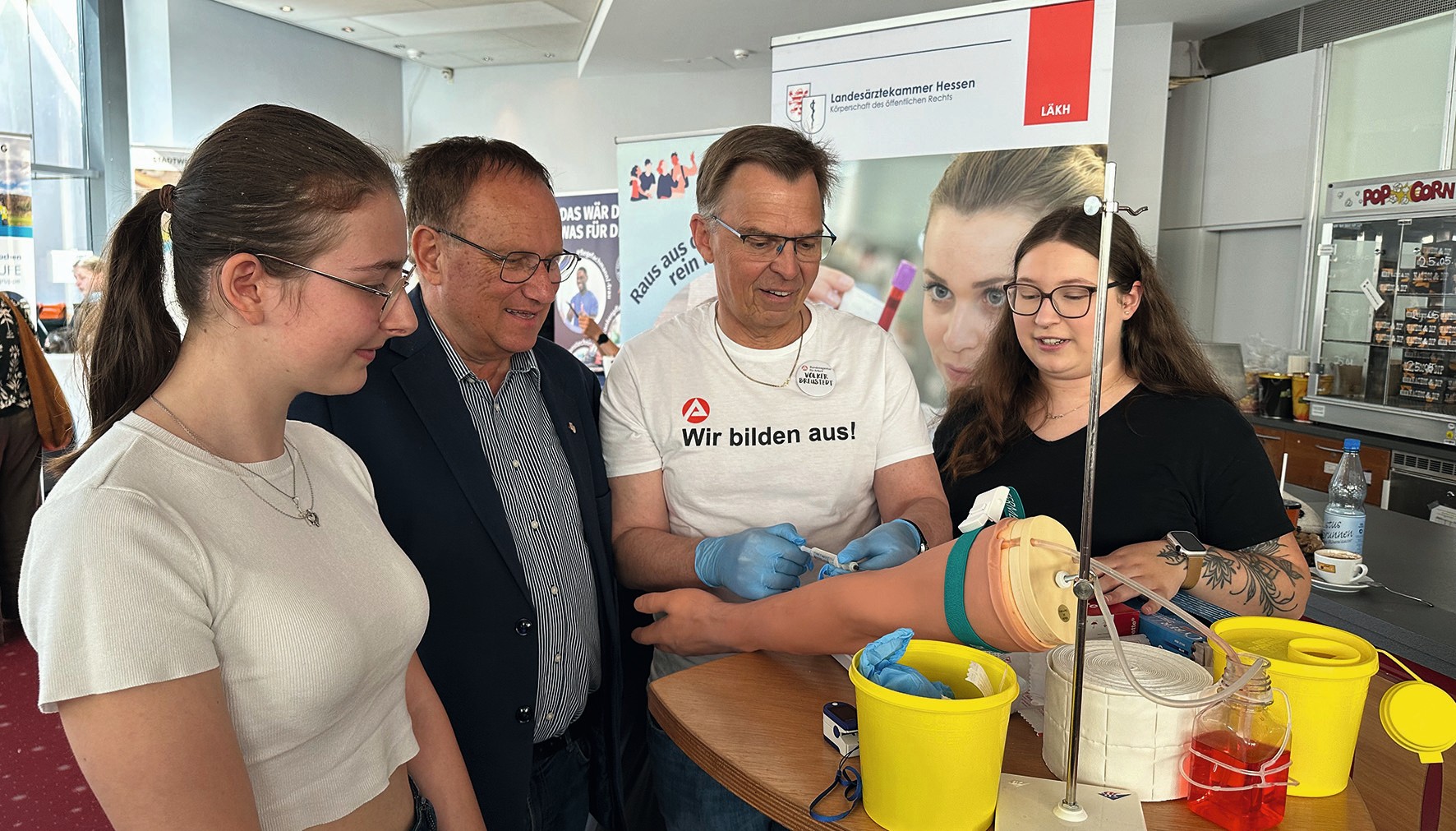 Reges Interesse am Messestand (von links): Leonie Heinrich (MFA-Auszubildende), Dr. med. Dipl.-Chem. Paul Otto Nowak (Vorsitzender der Bezirksärztekammer Marburg), Volker Breustedt (Vorsitzender der Geschäftsführung der Agentur für Arbeit Marburg), Le