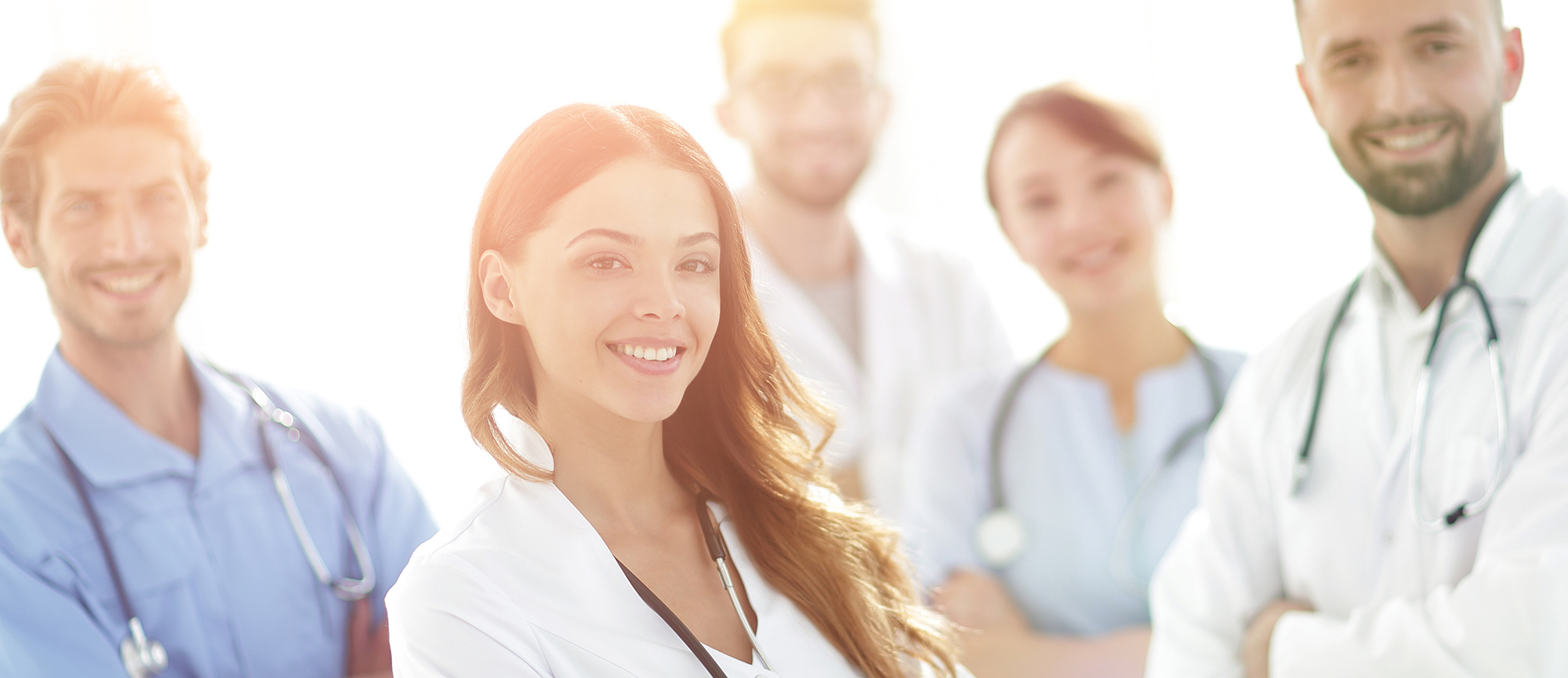 Startbild: Foto von einer Gruppe von Ärztinnen und Ärzten, im Vordergrund eine lächelnde junge Ärztin